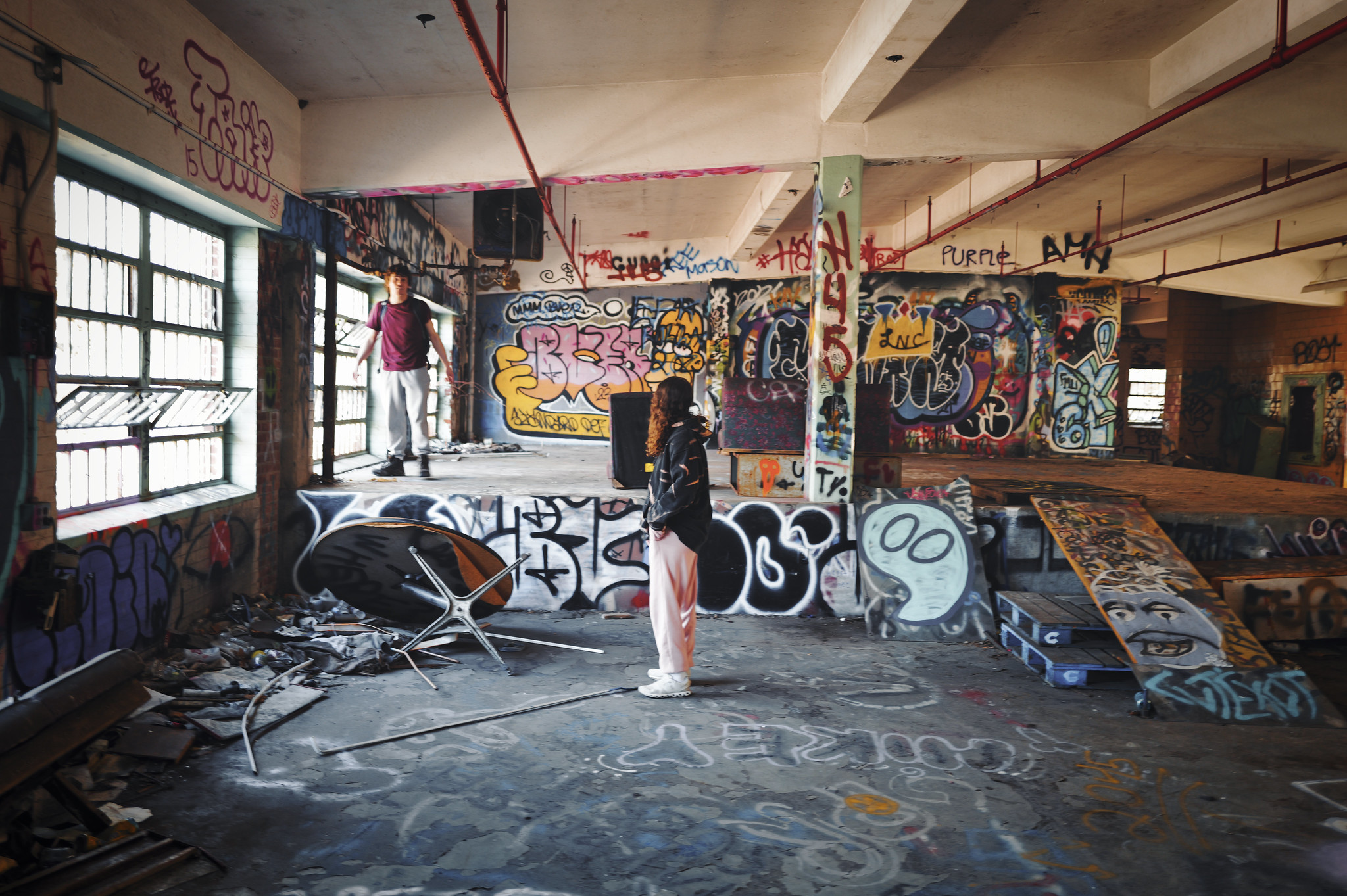 Two Adults Standing Inside An Indoor Skatepark