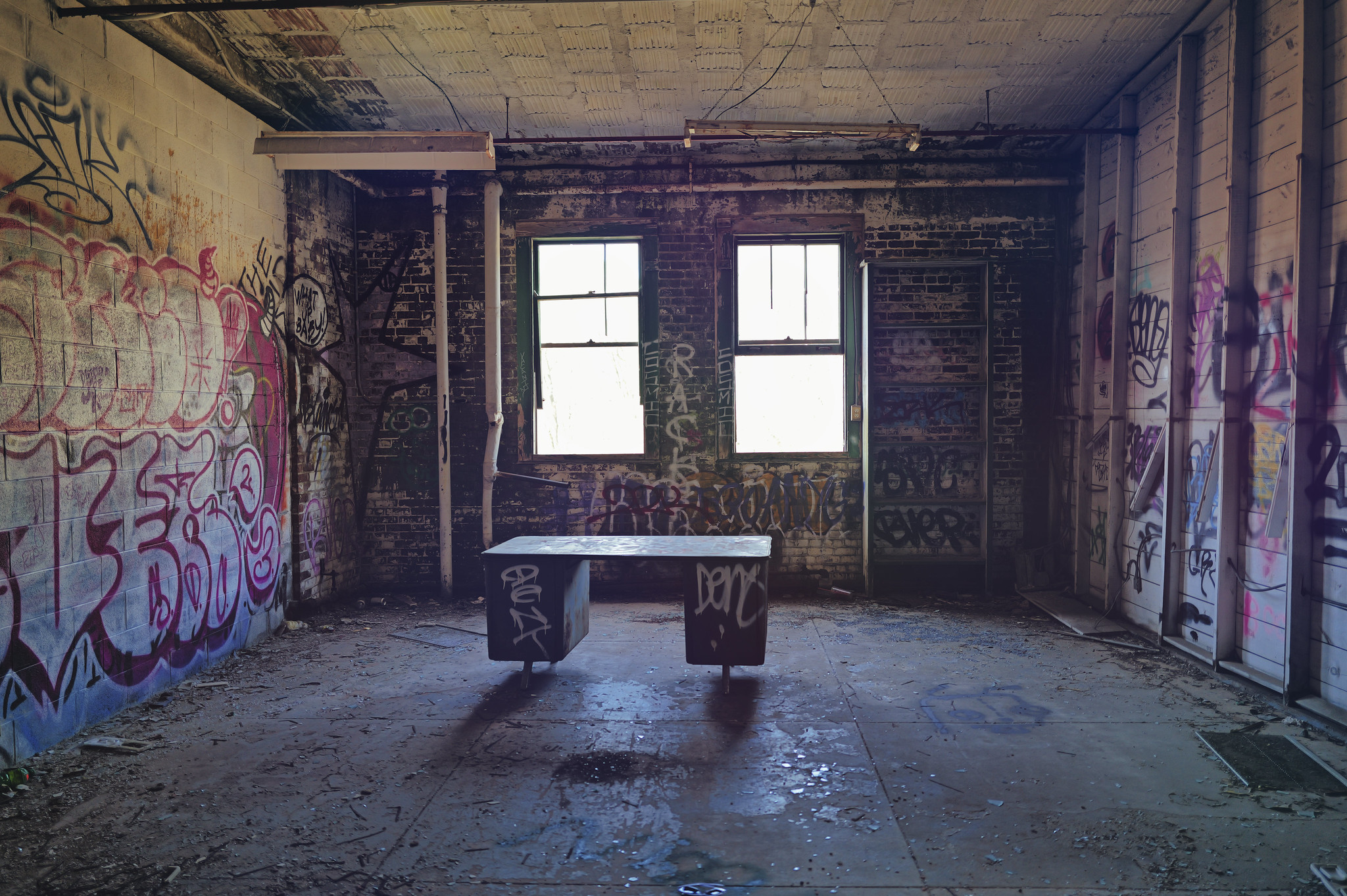A Single 1950's Style Desk In The Middle Of An Abandoned Warehouse